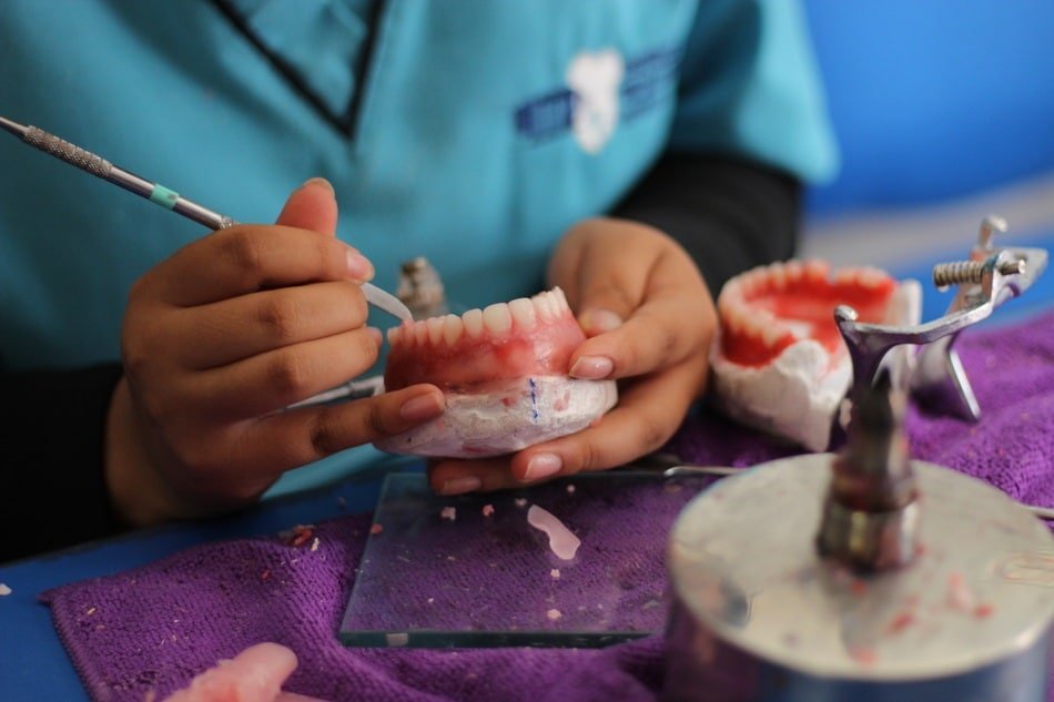 estudiante realizando una restauración de protesis durante diplomado de cerámica dental
