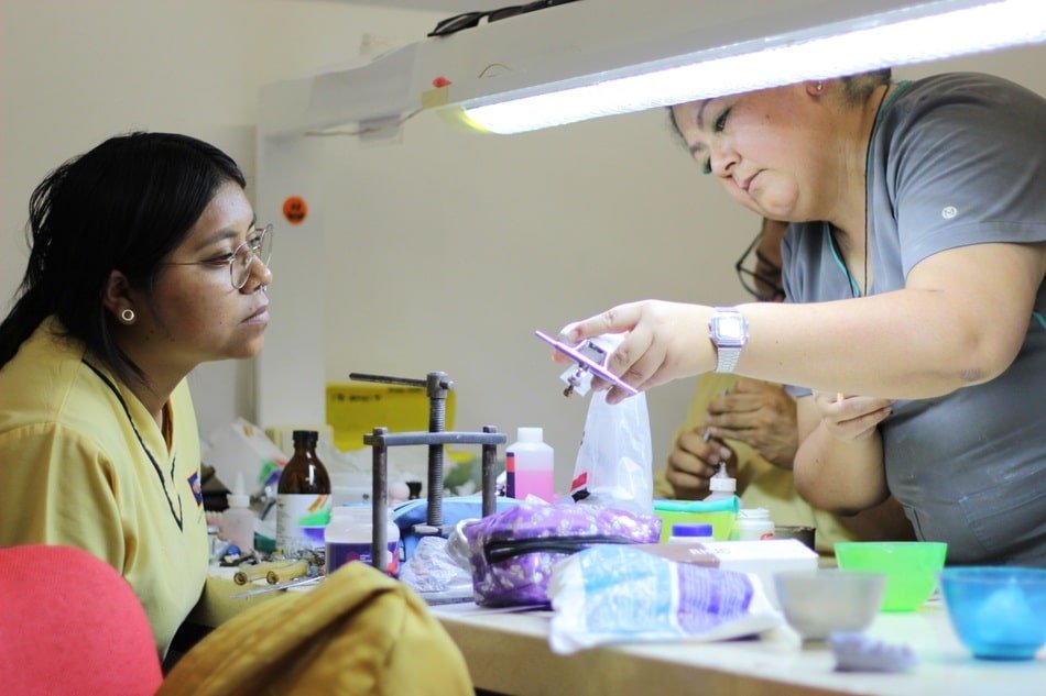 clase de diplomado en protesis dental con maestra explicando a alumna