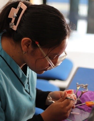 estudiante realizando una confección de protesis durante clase